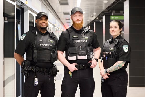 3 agents de sécurité regardant la caméra sur un quai de train
